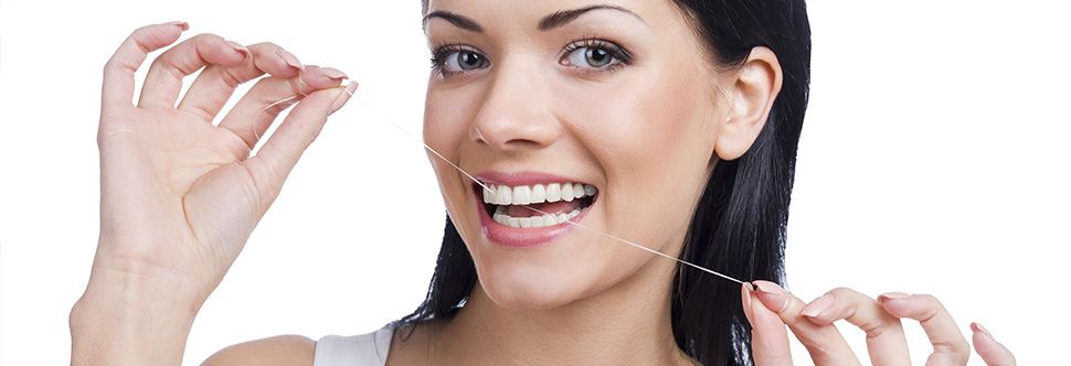 Clínica Dental Dr. Verástegui mujer limpiando dentadura con hilo